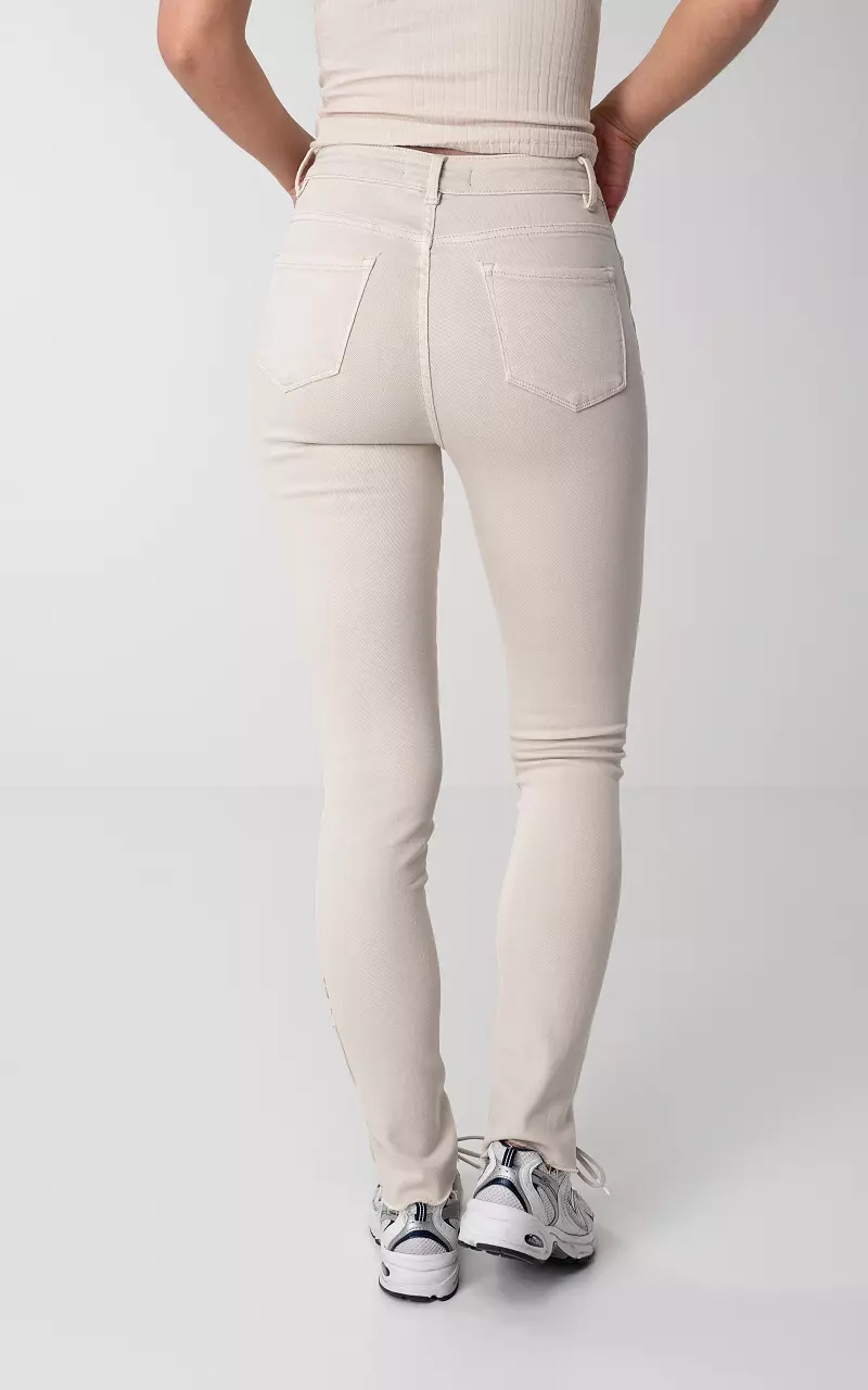 High-waist skinny jeans with split Cream